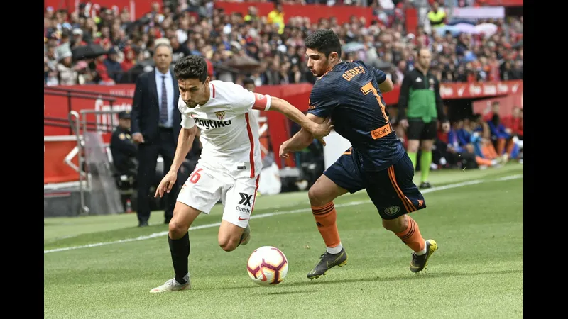 Cầu thủ của Valencia đang nỗ lực vượt qua sự chặn đứng của hậu vệ Sevilla